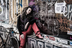 Daniela Mitterlehner - Frau sitzt nachdenklich vor Schaufenster